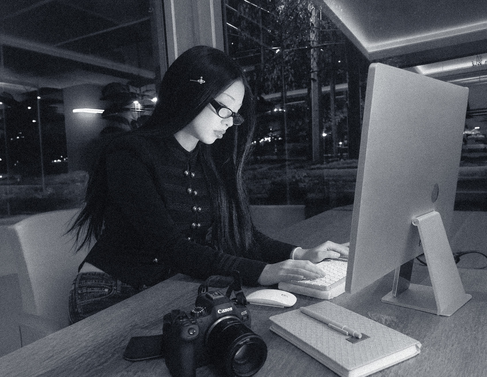 Hana at her desk at night, camera beside the keyboard